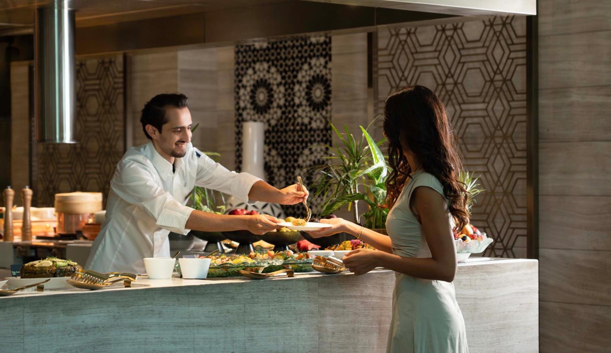 Fairmont Riyadh Riade Exterior foto A chef serving a guest at the buffet